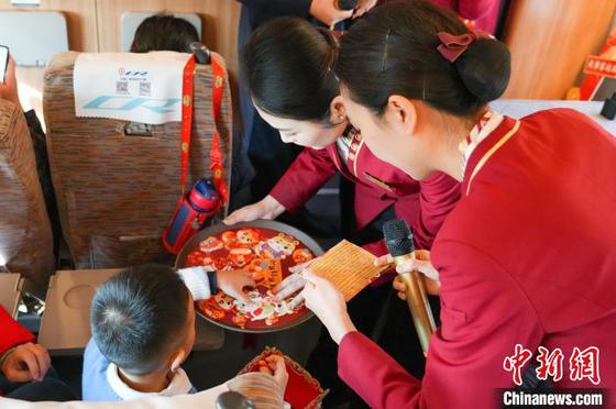 22日,在天津西开往香港西九龙的G305次列车上,一场具有浓郁年俗文化韵味的“小年联欢会”上演。 刘超 摄 22日,在天津西开往香港西九龙的G305次列车上,一场具有浓郁年俗文化韵味的“小年联欢会”上演。 刘超 摄