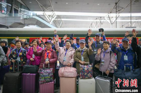 3月15日,天津站,旅客们在站台上挥手示意,准备登车。中新社记者 佟郁 摄