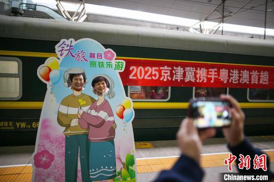 3月15日,天津站,两名旅客在主题合影墙拍照留念。中新社记者 佟郁 摄