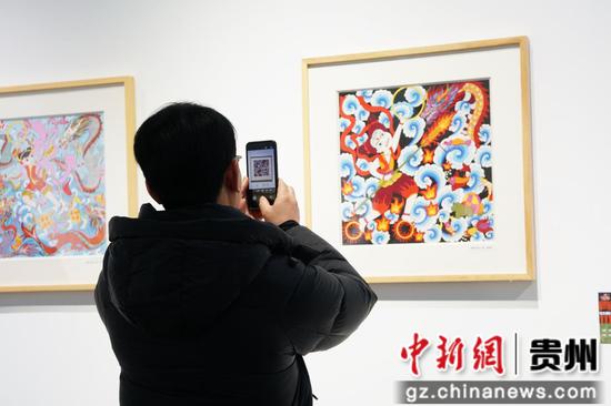 此次展出的作品引前来观赏的游客拍照。王秋旭摄 此次展出的作品引前来观赏的游客拍照。王秋旭摄