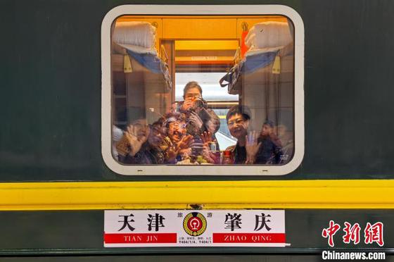 3月15日,天津站,车厢里的旅客挥手告别。当日,京津冀携手粤港澳“京铁乐游”银发旅游列车首发仪式在天津站举行。本次列车搭载150名天津游客,与来自北京、河北省的游客同行,途经江西、湖南、广东三省的5个5A级景区及6个4A级景区,共同开启为期12天的南北文化交融之旅。中新社记者 佟郁 摄