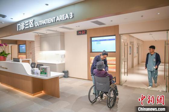 2月26日，天津，医护人员在医院门诊区陪伴患者候诊。中新社记者 佟郁 摄