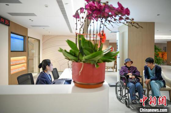 2月26日，天津，医护人员在医院大厅等待休息区陪伴患者候诊。当日，由新加坡鹏瑞利集团全资建设的中国首家外商独资三级综合医院天津鹏瑞利医院正式开诊。鹏瑞利医院位于天津市西青区，拥有500张床位，总投资额约10亿元人民币，设置骨科、眼耳鼻喉、肾病及免疫疾病、心血管、肿瘤等科室，并设有国际部。中新社记者 佟郁 摄