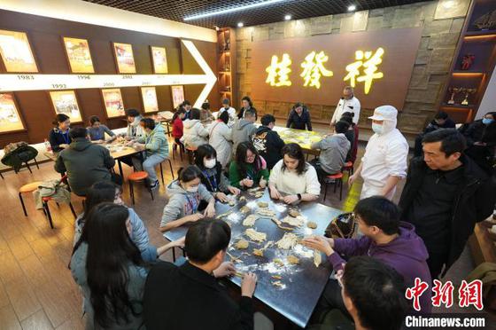 两岸青年共同体验桂发祥十八街麻花制作技艺。天津市台联供图 两岸青年共同体验桂发祥十八街麻花制作技艺。天津市台联供图