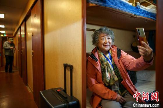 3月15日,天津站,一名旅客在车厢里用手机自拍。中新社记者 佟郁 摄