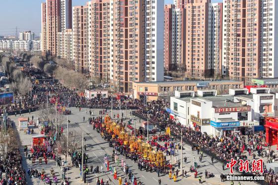 2月13日,中国农历正月十六,有着600多年历史的中国国家级非物质文化遗产代表性项目“葛沽宝辇会”在天津津南区葛沽镇上演,市民和游客汇聚于此,感受津沽海下传统民俗带来的欢乐与祥和。图为民众观看葛沽宝辇会。中新社记者 佟郁 摄