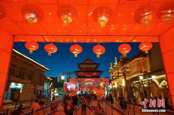 2月3日晚,市民和游客在天津鼓楼“大明风华巷鼓楼奇趣夜”古风光影市集打卡游玩,沉浸式体验“津”彩假期夜。中新社记者 佟郁 摄