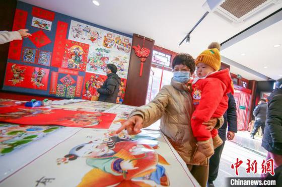 1月29日,中国农历大年初一,天津古文化街红灯笼高挂,游人如织,八方游客穿梭于青石板铺就的老街,看民俗,品美食,听相声,体验“津味儿”年俗迎新春。图为游客参观天津杨柳青年画。中新社记者 佟郁 摄 1月29日,中国农历大年初一,天津古文化街红灯笼高挂,游人如织,八方游客穿梭于青石板铺就的老街,看民俗,品美食,听相声,体验“津味儿”年俗迎新春。图为游客参观天津杨柳青年画。中新社记者 佟郁 摄