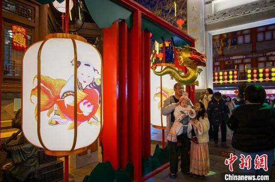 2月9日晚,市民和游客在天津西青区杨柳青古镇赏花灯,游玩拍照。中新社记者 佟郁 摄