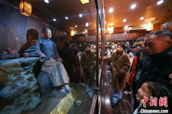 1月29日,中国农历大年初一,天津古文化街红灯笼高挂,游人如织,八方游客穿梭于青石板铺就的老街,看民俗,品美食,听相声,体验“津味儿”年俗迎新春。图为游客在天津古文化街参观中国国家级非物质文化遗产泥人张彩塑。中新社记者 佟郁 摄 1月29日,中国农历大年初一,天津古文化街红灯笼高挂,游人如织,八方游客穿梭于青石板铺就的老街,看民俗,品美食,听相声,体验“津味儿”年俗迎新春。图为游客在天津古文化街参观中国国家级非物质文化遗产泥人张彩塑。中新社记者 佟郁 摄