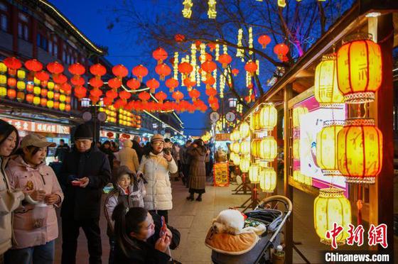 2月9日晚,市民和游客在天津西青区杨柳青古镇赏花灯,游玩拍照。中新社记者 佟郁 摄