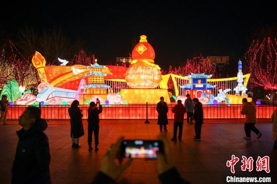 2月9日晚,市民和游客在天津西青区杨柳青古镇赏花灯,游玩拍照。中新社记者 佟郁 摄