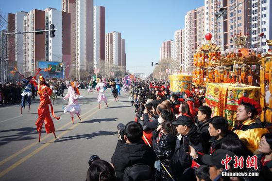 2月13日,中国农历正月十六,有着600多年历史的中国国家级非物质文化遗产代表性项目“葛沽宝辇会”在天津津南区葛沽镇上演,市民和游客汇聚于此,感受津沽海下传统民俗带来的欢乐与祥和。图为民众观看高跷展演。中新社记者 佟郁 摄