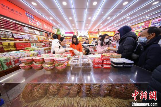 1月29日,中国农历大年初一,天津古文化街红灯笼高挂,游人如织,八方游客穿梭于青石板铺就的老街,看民俗,品美食,听相声,体验“津味儿”年俗迎新春。图为游客在天津古文化街果仁张选购特色食品。中新社记者 佟郁 摄 1月29日,中国农历大年初一,天津古文化街红灯笼高挂,游人如织,八方游客穿梭于青石板铺就的老街,看民俗,品美食,听相声,体验“津味儿”年俗迎新春。图为游客在天津古文化街果仁张选购特色食品。中新社记者 佟郁 摄