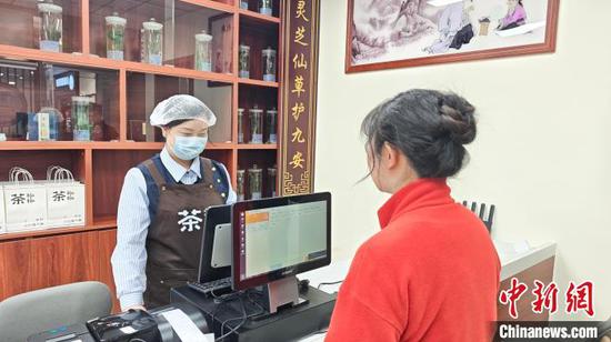 顾客正在购买新中式药食同源茶饮。施乐 摄