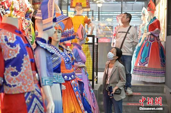 资料图为广西南宁市民挑选各色民族服饰。 资料图为广西南宁市民挑选各色民族服饰。