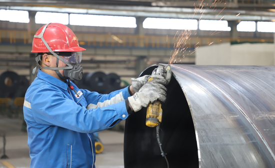3月17日，宝石管业克拉玛依公司厂房内，技术工人在修磨钢管表面。陈飞鹏 摄