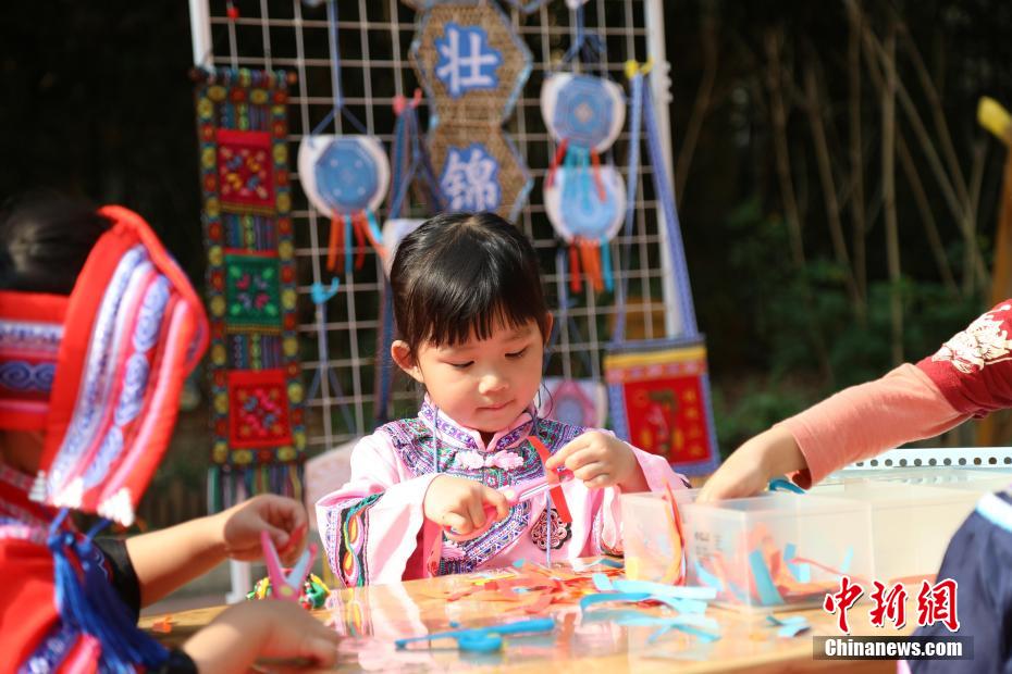 3月27日，在广西南宁市邕宁区一所幼儿园内，师生身着民族服装参加“三月三”民俗活动，通过体验民俗美食一条街、民俗手工一条街的形式，欢度充满童趣与文化气息的“三月三”。图为活动现场。卢虹灵 摄
