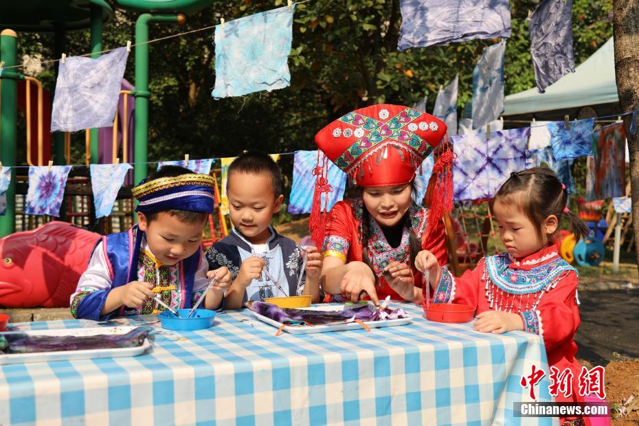 3月27日，在广西南宁市邕宁区一所幼儿园内，师生身着民族服装参加“三月三”民俗活动，通过体验民俗美食一条街、民俗手工一条街的形式，欢度充满童趣与文化气息的“三月三”。图为活动现场。卢虹灵 摄