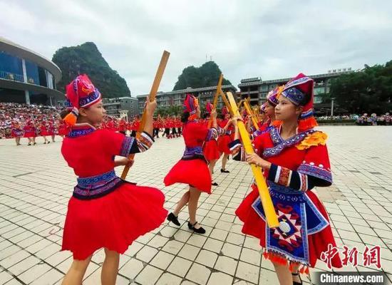 在南宁市马山县,民众唱响山歌,展演打扁担等特色民俗。黄艳梅 摄 在南宁市马山县,民众唱响山歌,展演打扁担等特色民俗。黄艳梅 摄