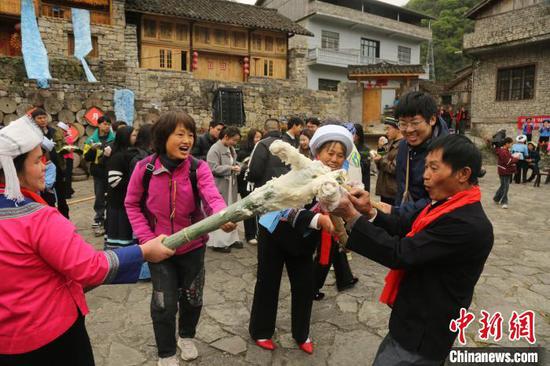 图为布依族同胞与宾客一起打糍粑迎佳节。叶方杰 摄