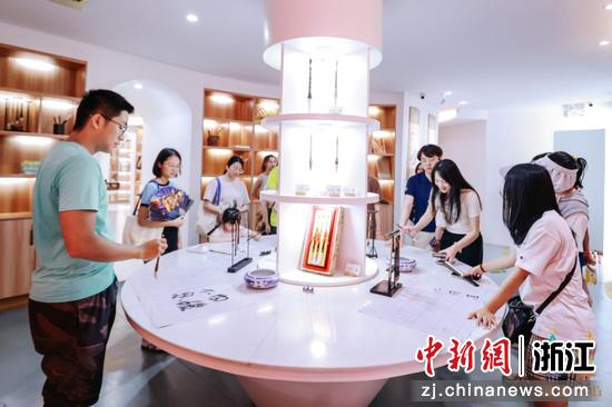 图为湖笔小镇,年轻人在体验毛笔书写。善琏镇供图 图为湖笔小镇,年轻人在体验毛笔书写。善琏镇供图