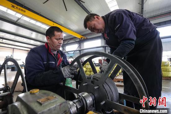 图为工人在整理电梯钢丝绳。中新社记者 瞿宏伦 摄 图为工人在整理电梯钢丝绳。中新社记者 瞿宏伦 摄