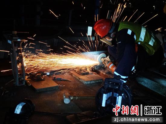 图为:工作人员精心打磨轨道设备。中新社发 贺瑞明 摄