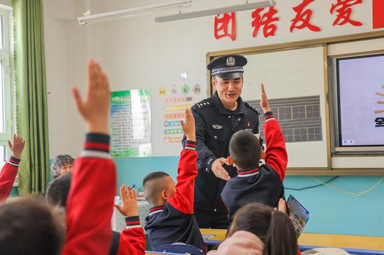 4 月 9 日，哈密公安处民警在花园乡第一小学开展 “415 全民国家安全教育”，与学生们积极互动。