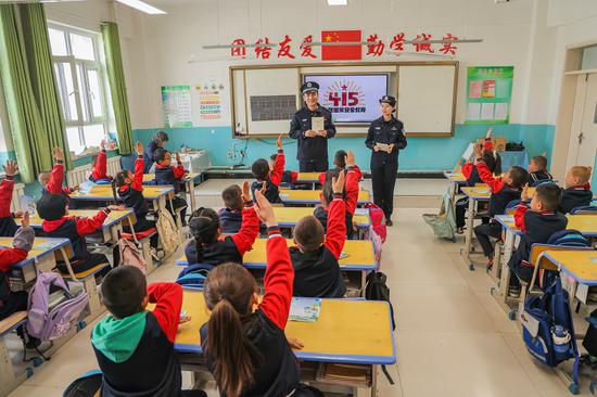 4 月 9 日，哈密公安处民警在花园乡第一小学开展 “415 全民国家安全教育”，与学生们积极互动。