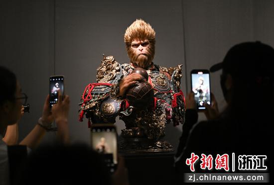 图为:多名参观者拍摄悟空模型。中新社记者 王刚 摄