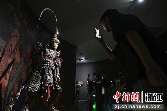 图为:多名参观者拍摄悟空模型。中新社记者 王刚 摄