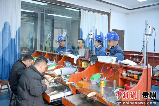 在丹寨县国春银饰有限责任公司，南方电网贵州凯里丹寨供电局工作人员了解用电需求。杨启志 摄