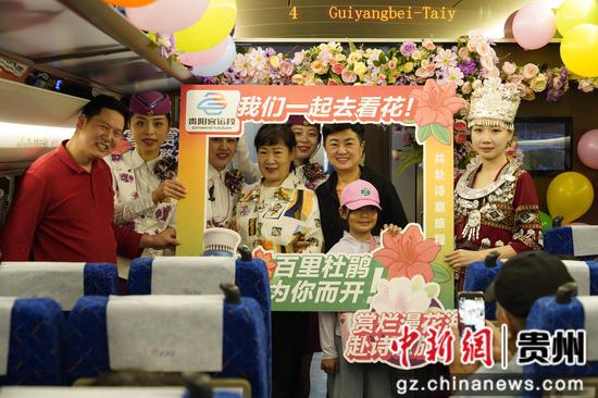 活动车厢内，旅客与“赏花列车”工作人员进行合照留念。游滨礼 摄