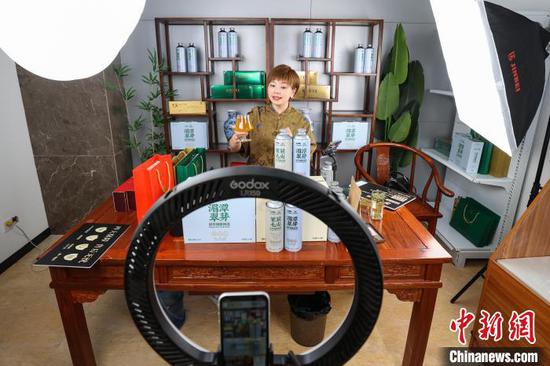 图为一位主播在茶博会现场直播带货“茶叶啤酒”。中新社记者 瞿宏伦 摄