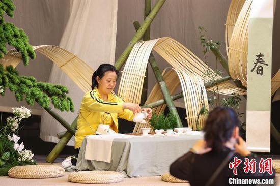 图为参观者在茶博会现场设置的茶艺打卡区拍照。中新社记者 瞿宏伦 摄