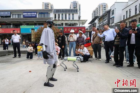 图为茶博会现场的智能机器人、机器狗吸引参观者。中新社记者 瞿宏伦 摄