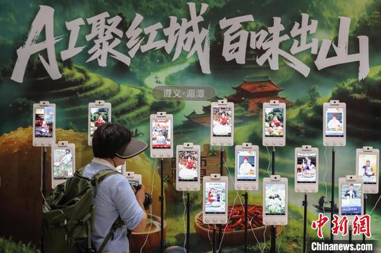 图为茶博会现场设置的“AI助农数字人直播”带茶、带农特产品吸引参观者，该直播AI主播24小时在线，可实现“智能互动+实时答疑”。中新社记者 瞿宏伦 摄