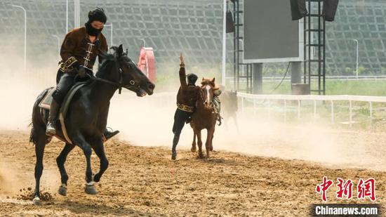 图为骑手表演马背上的特技。陈洋昕 摄