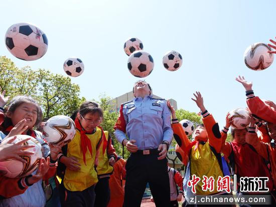 图为:民警和小朋友开展体育交流互动。中新社发 贺瑞明 摄