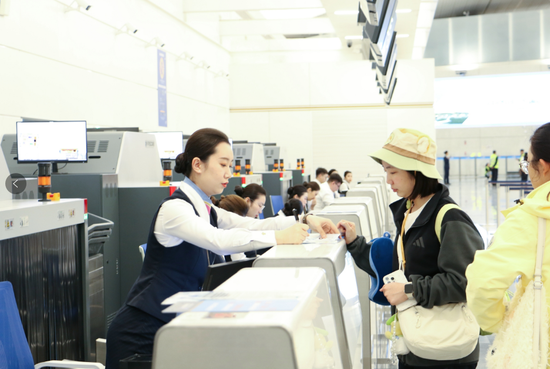 南航工作人員為旅客辦理值機(jī)服務(wù)。 高若彬  攝