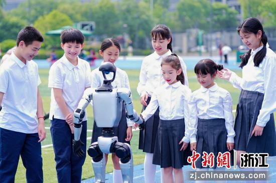 图为学生与机器人互动。（主办方供图）