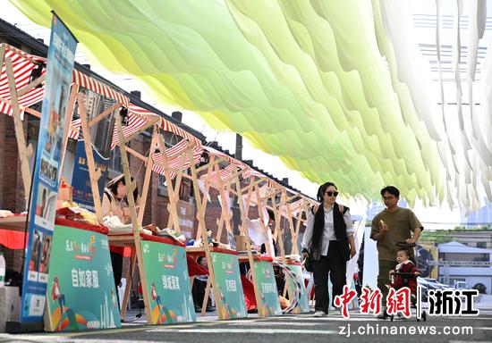 图为:年轻人带孩子逛租房市集。中新社记者 王刚 摄