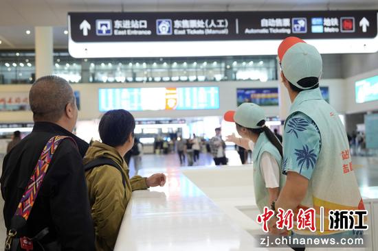 图为:“站小青”志愿者为旅客提供咨询引导服务。中新社发 徐虎 摄