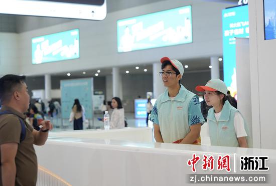 图为:“站小青”志愿者为旅客服务。中新社发 徐虎 摄
