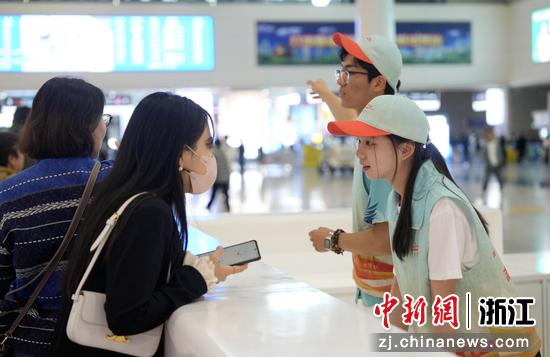 图为:“站小青”志愿者为旅客提供咨询引导服务。中新社发 徐虎 摄
