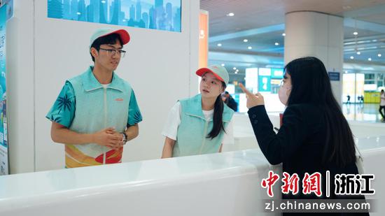 图为:“站小青”志愿者为旅客服务。中新社发 徐虎 摄