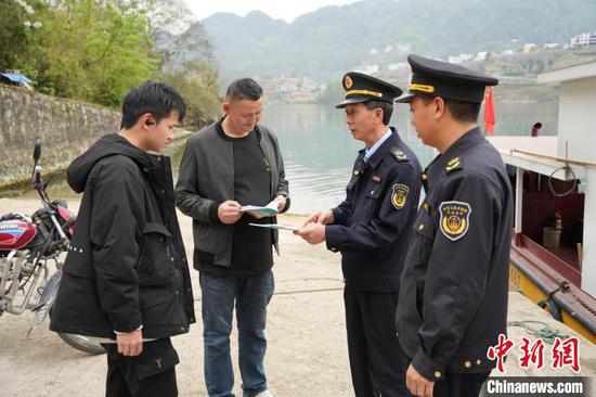 图为喻猛和队员向民众发放宣传资料并进行政策讲解。周燕玲 摄 图为喻猛和队员向民众发放宣传资料并进行政策讲解。周燕玲 摄