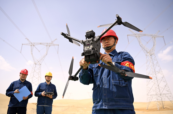 4月27日，新疆送變電公司員工應(yīng)用無(wú)人機(jī)對(duì)750千伏巴羅一二線進(jìn)行保電巡視。圖為飛行前的校準(zhǔn)。馬元 攝