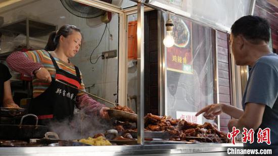 图为游客在青岩古镇内购买“青岩猪脚”。石小杰 摄